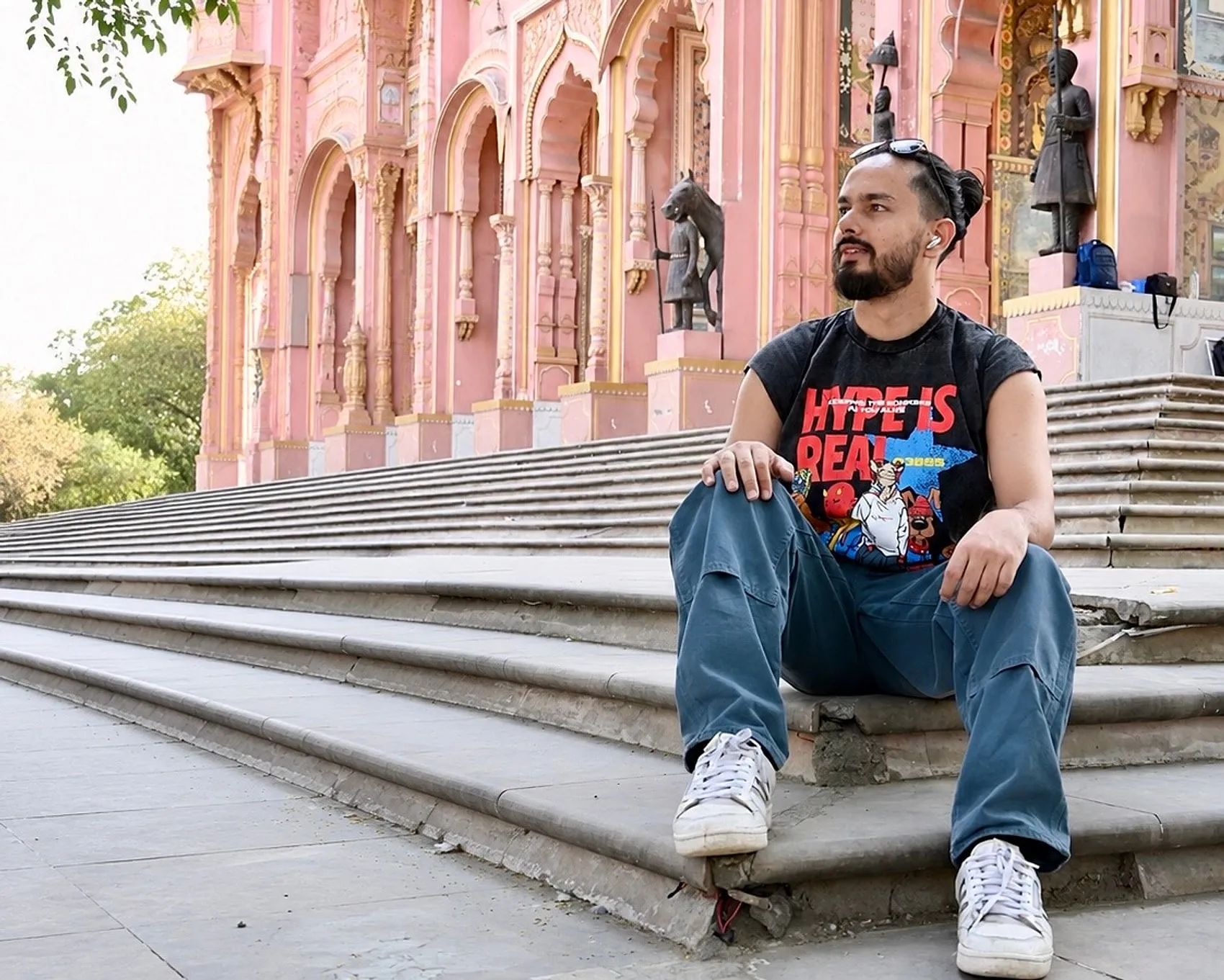 Lokesh sitting against the pink architecture of a Jaipur palace.