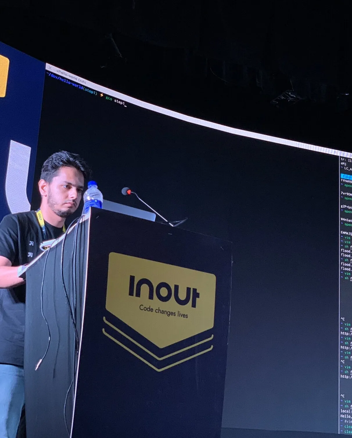 Lokesh live-coding from a lectern during a technical stage talk.